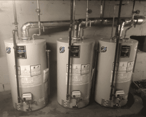 three hot water heaters in a mechanical room.