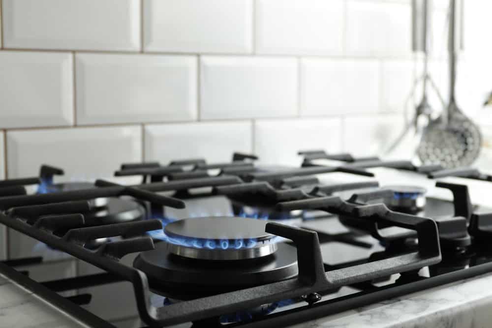 Gas stove burner with blue flame, reliable plumbing and heating services in NYC.