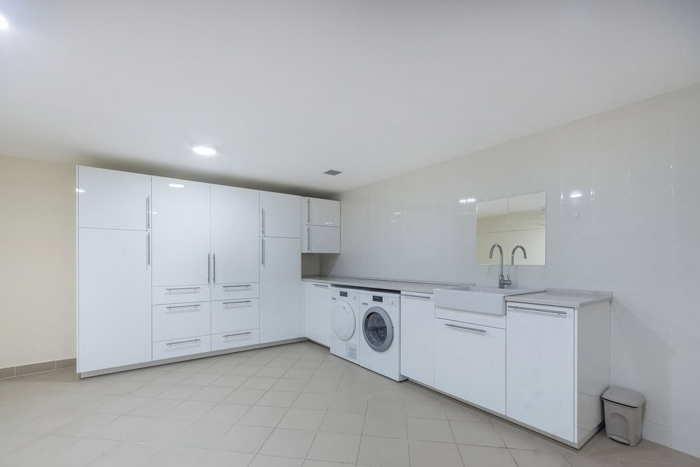 Modern laundry room with plumbing fixtures and white cabinetry for home plumbing needs.