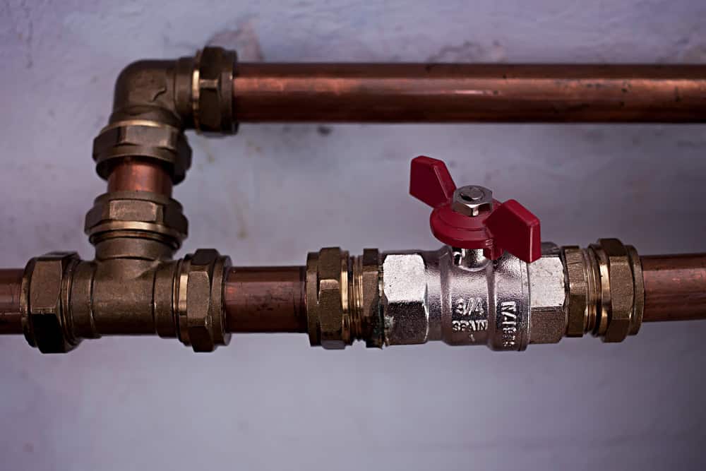 Leak-proof brass shut-off valve with copper piping for plumbing repair or installation.